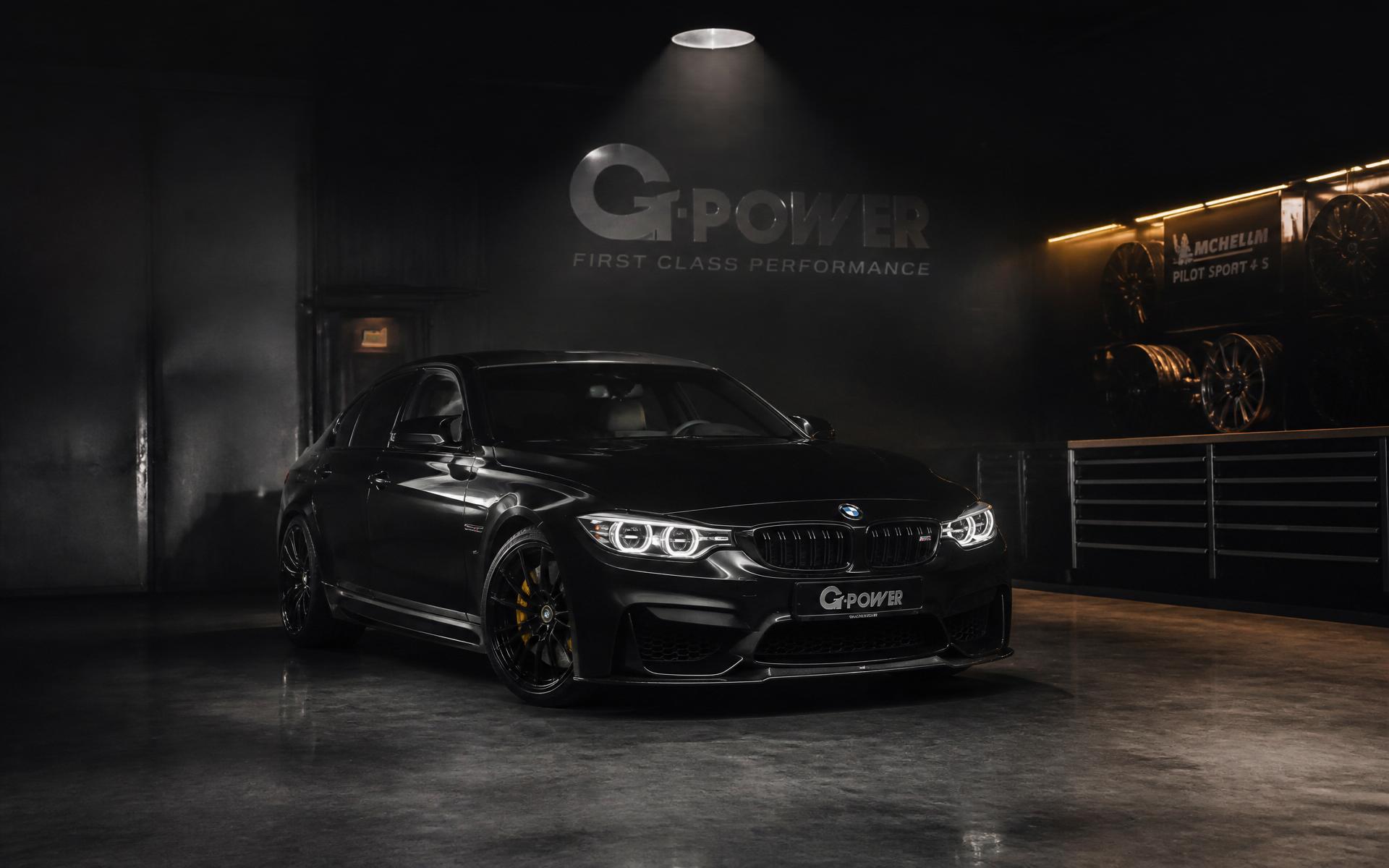 Black BMW performance sedan in a premium tuning shop